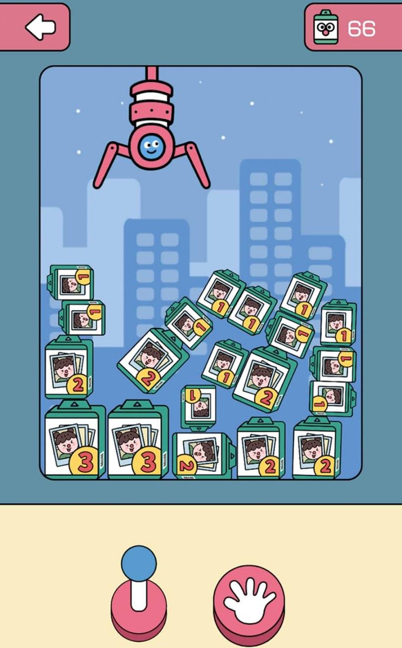 A screenshot of KaCaKaCa showcasing a large claw grabbing prizes from a claw machine depicted in a photograph.
